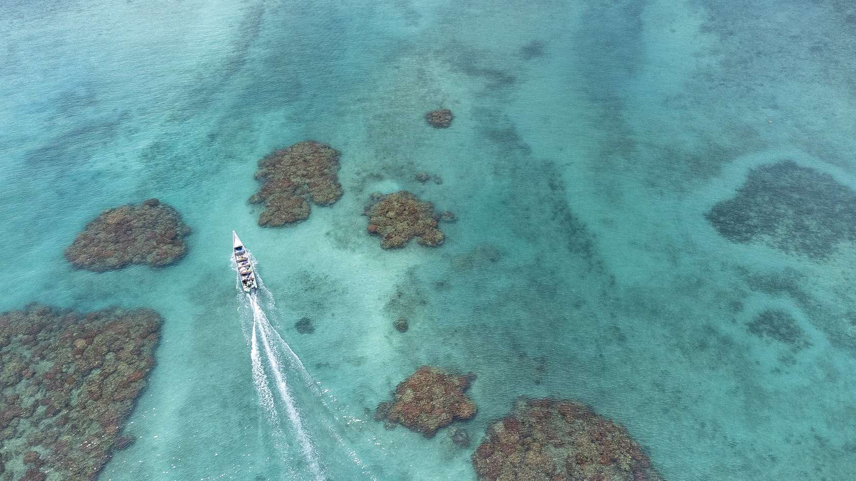 Vue aérienne d'un bateau naviguant entre les récifs, Sapzurro (Choco caribéen), Colombie