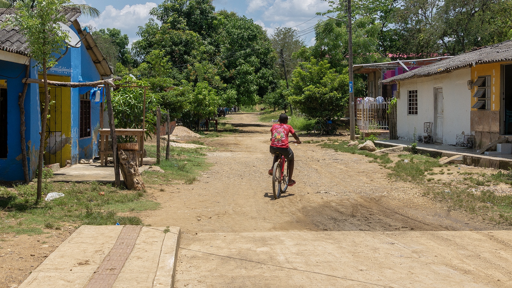 Enfant faisant du vélo dans rue sommaire, San Basilio de Palenque, Colombie